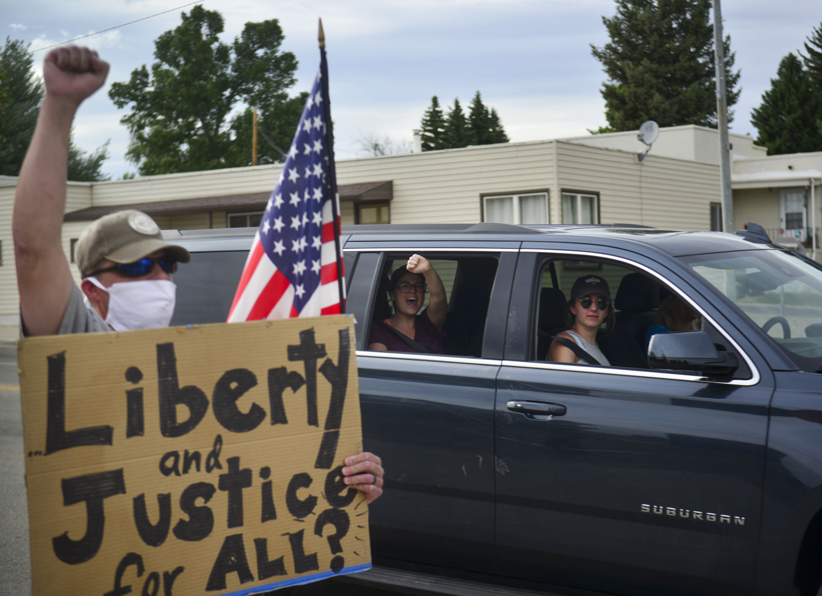 Steve Heil holds holds his fist in the air as a passing car cheers